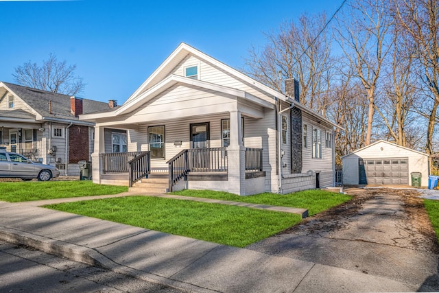 bungalow-style house with an outbuilding, a porch, a garage, and a front yard