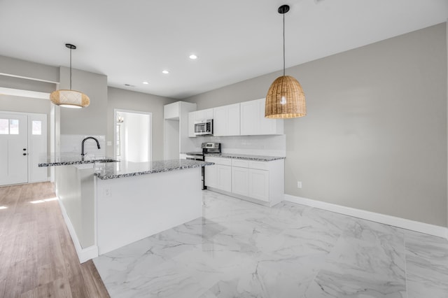 kitchen with decorative light fixtures, stainless steel appliances, white cabinets, and stone countertops