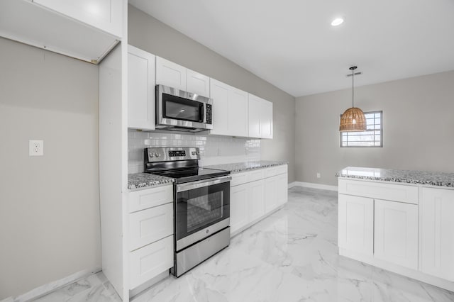 kitchen featuring white cabinetry, appliances with stainless steel finishes, pendant lighting, light stone countertops, and backsplash