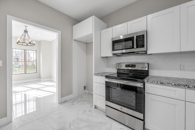 kitchen with backsplash, light stone countertops, white cabinets, and appliances with stainless steel finishes