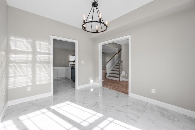 unfurnished room featuring an inviting chandelier