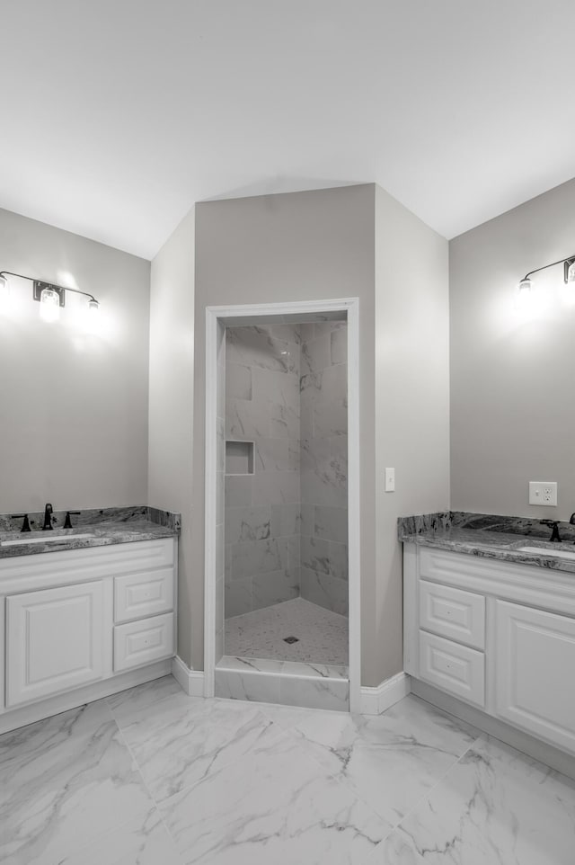 bathroom with tiled shower and vanity