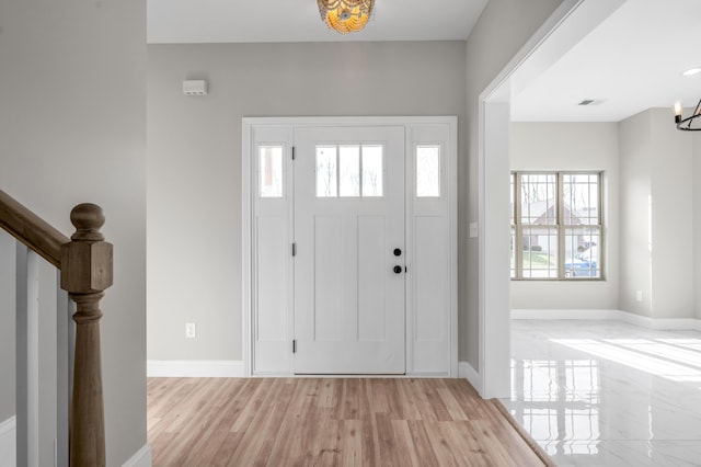 foyer with an inviting chandelier and light hardwood / wood-style flooring