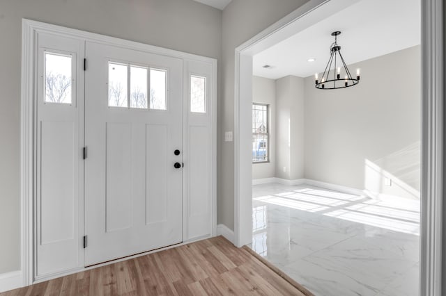 foyer with a chandelier and light wood-type flooring