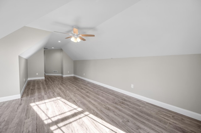 additional living space featuring ceiling fan, vaulted ceiling, and light wood-type flooring