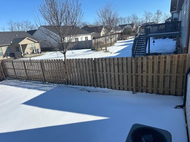 yard layered in snow with a wooden deck