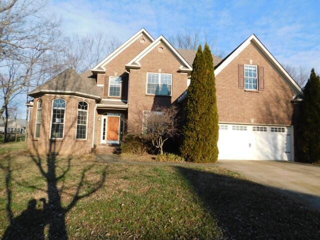 front facade featuring a garage and a front yard