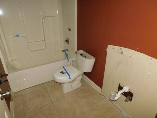 bathroom featuring shower / tub combination, tile patterned floors, and toilet