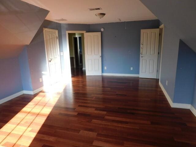 additional living space with dark hardwood / wood-style flooring