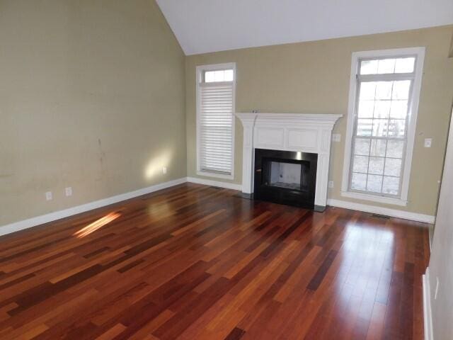 unfurnished living room with vaulted ceiling and dark hardwood / wood-style floors