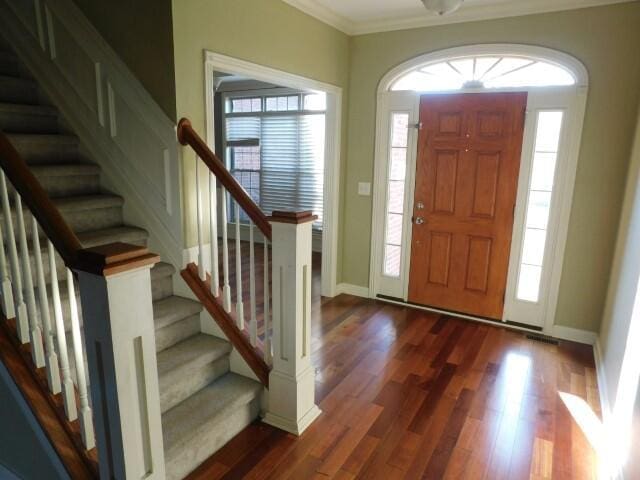 foyer featuring ornamental molding and dark hardwood / wood-style floors