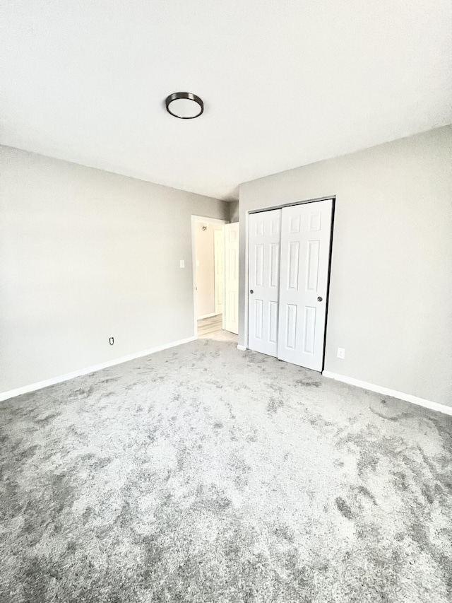 unfurnished bedroom featuring carpet flooring and a closet