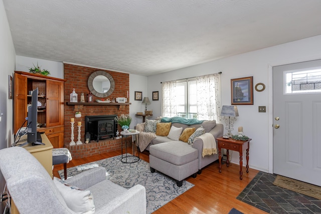 living room with a wealth of natural light, a textured ceiling, and light hardwood / wood-style floors