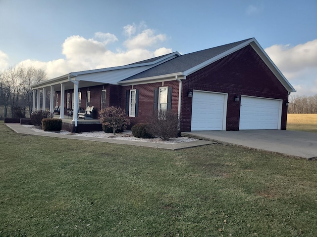 view of front of house featuring a garage, covered porch, and a front lawn