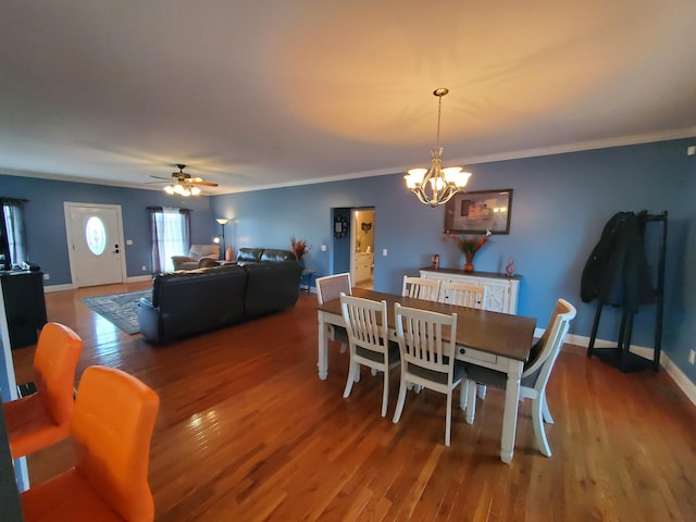 dining space with hardwood / wood-style flooring, ceiling fan with notable chandelier, and ornamental molding