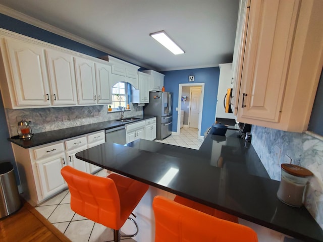 kitchen with appliances with stainless steel finishes, sink, backsplash, a kitchen bar, and kitchen peninsula