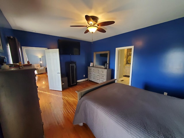 bedroom featuring light hardwood / wood-style flooring, ceiling fan, and ensuite bathroom