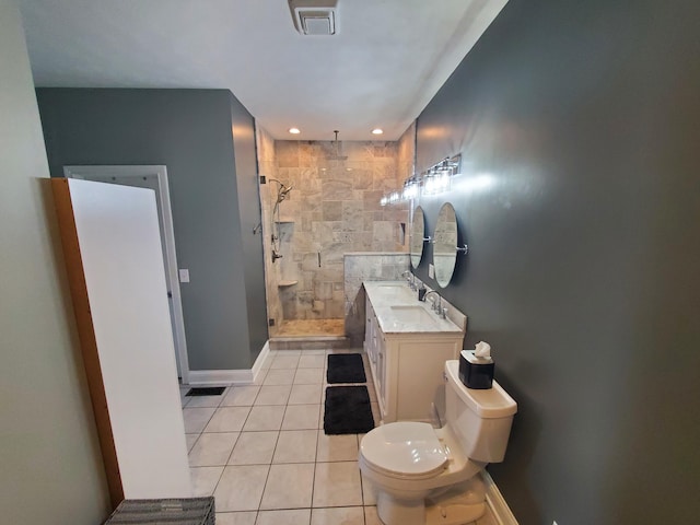 bathroom with tiled shower, tile patterned floors, toilet, and vanity