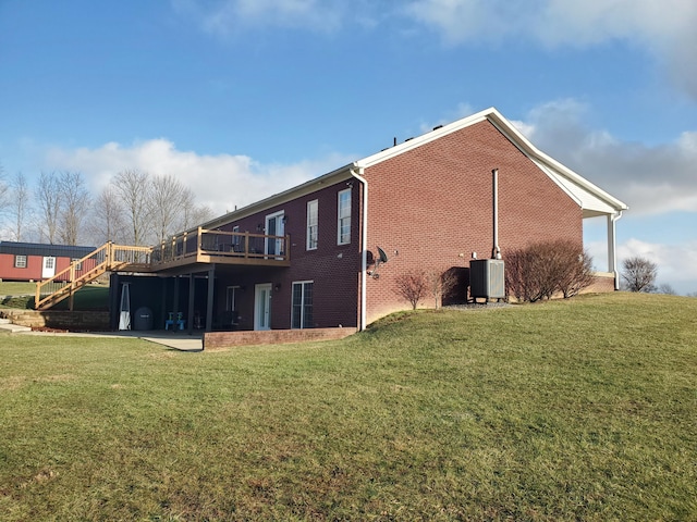 rear view of house featuring a yard, central AC, and a deck