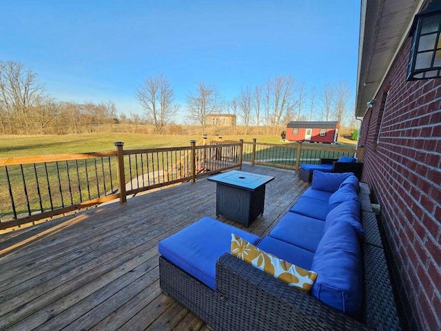 deck featuring a lawn and an outdoor living space with a fire pit