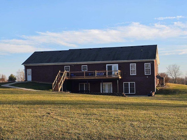 back of property with a wooden deck and a lawn