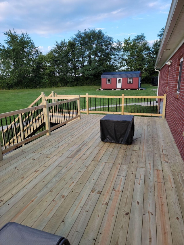 wooden terrace with a lawn and a storage unit