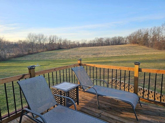 wooden deck featuring a rural view and a yard