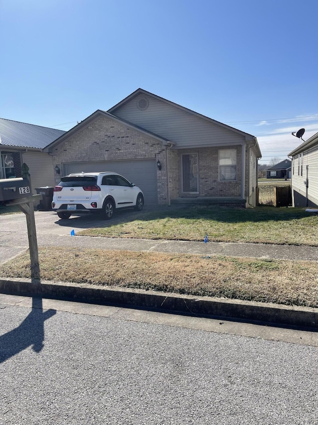 view of front of house featuring a front lawn, brick siding, driveway, and an attached garage