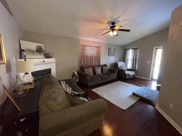 living area with lofted ceiling, a fireplace, baseboards, and dark wood finished floors