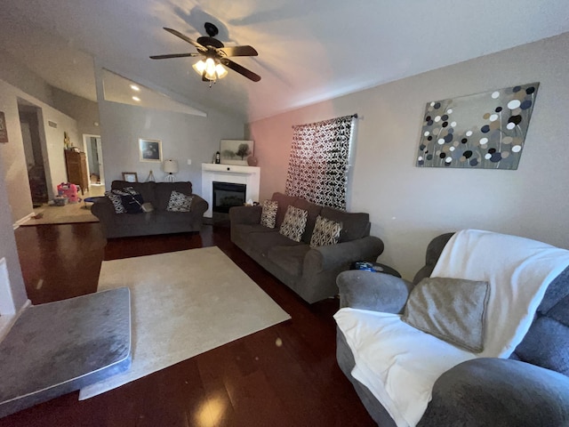 living room featuring a ceiling fan, lofted ceiling, a glass covered fireplace, and wood finished floors