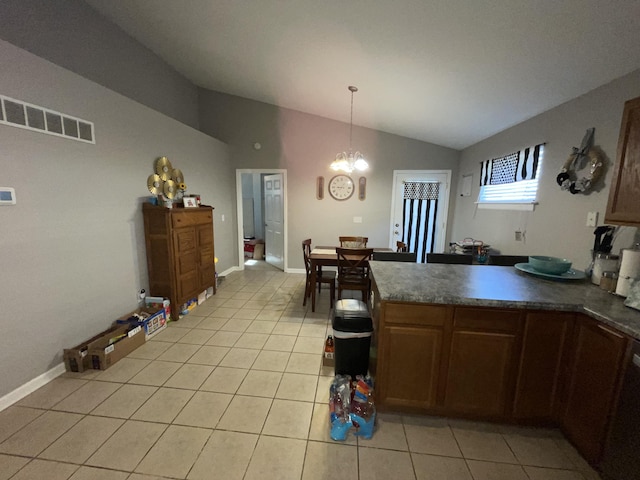 kitchen with vaulted ceiling, light tile patterned floors, a notable chandelier, and decorative light fixtures