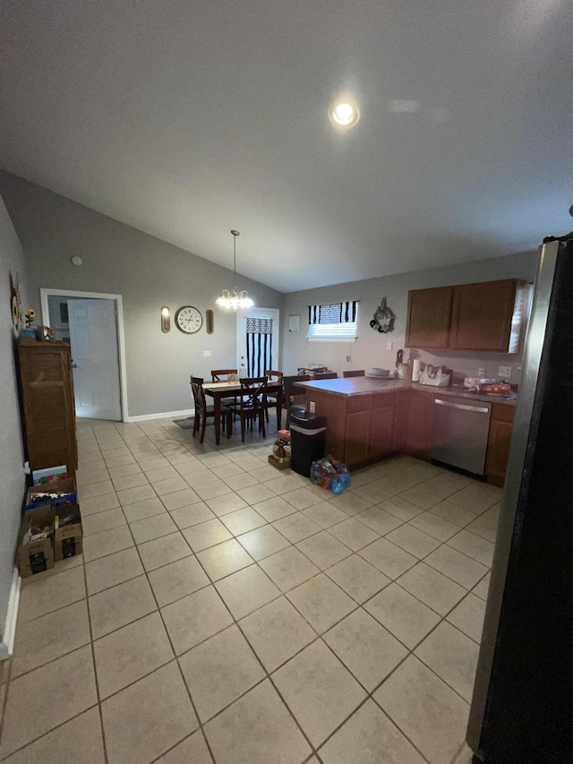 kitchen featuring pendant lighting, vaulted ceiling, light tile patterned flooring, and appliances with stainless steel finishes