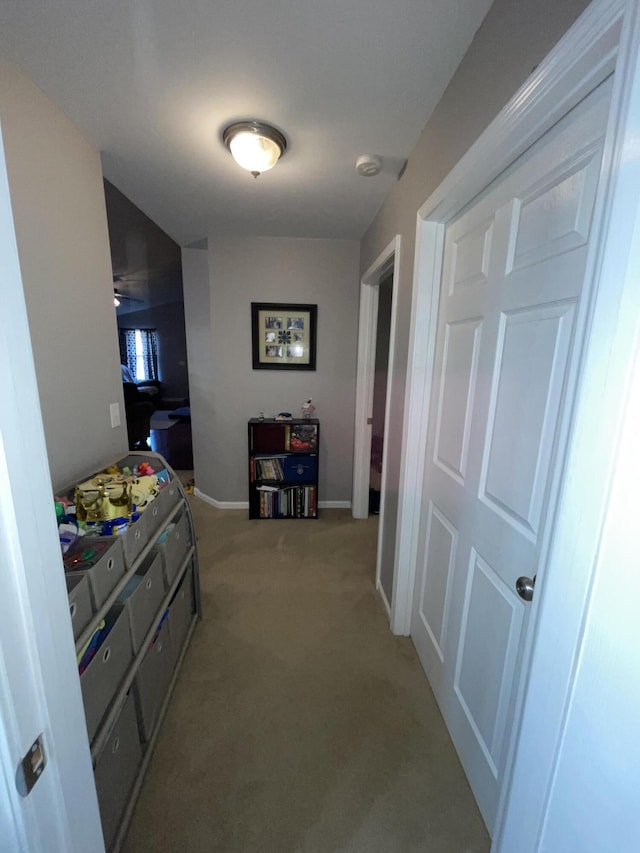 hall featuring light carpet and baseboards