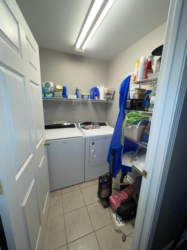 clothes washing area featuring washing machine and dryer and light tile patterned floors