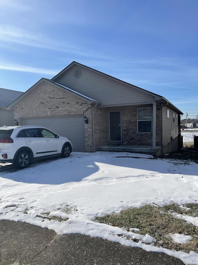 view of front of property with a garage, driveway, and brick siding