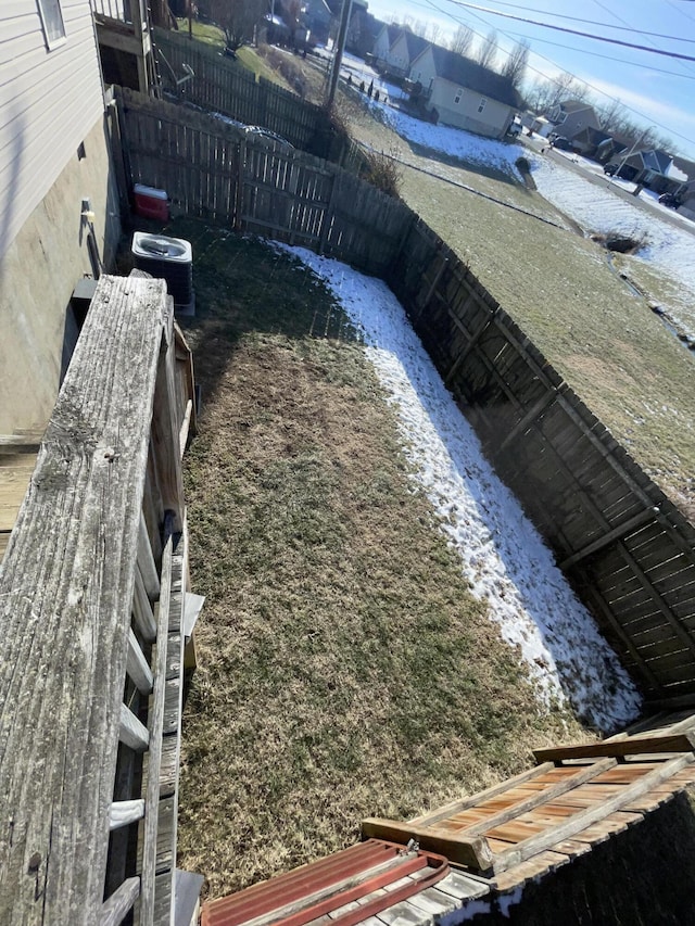 view of yard with central AC and fence