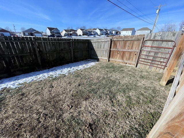 view of yard featuring a residential view, a gate, and a fenced backyard