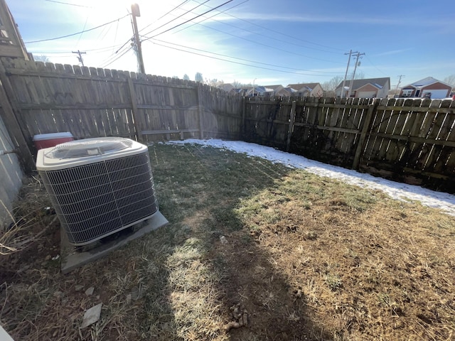 view of yard with a fenced backyard and central AC unit