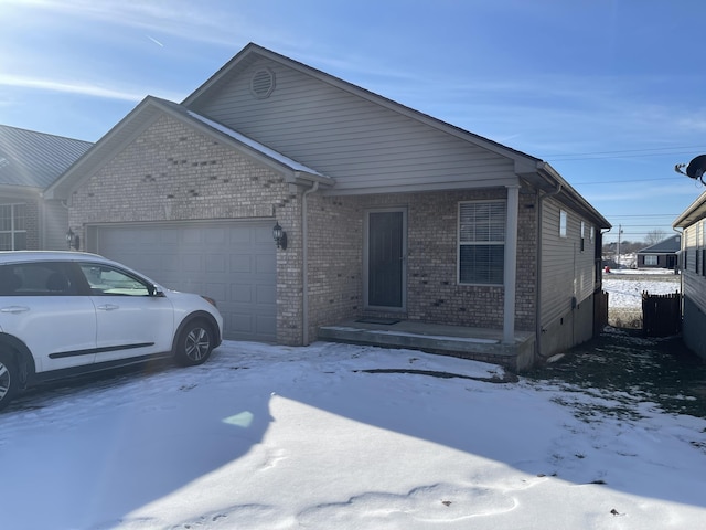 view of front of house featuring a garage, fence, and brick siding