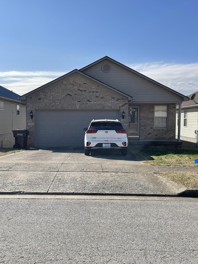 view of front of house featuring a garage, brick siding, and driveway