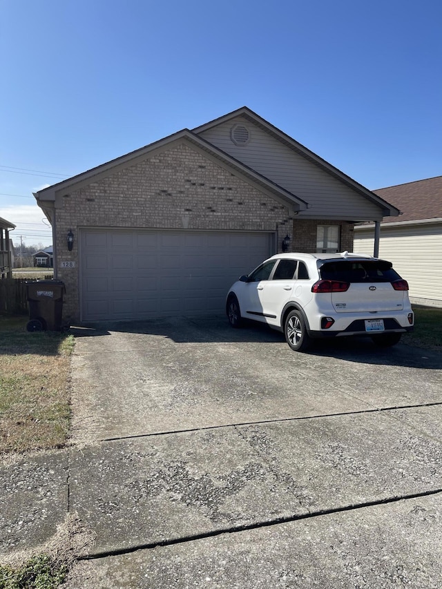 view of front of house featuring a garage, concrete driveway, and brick siding