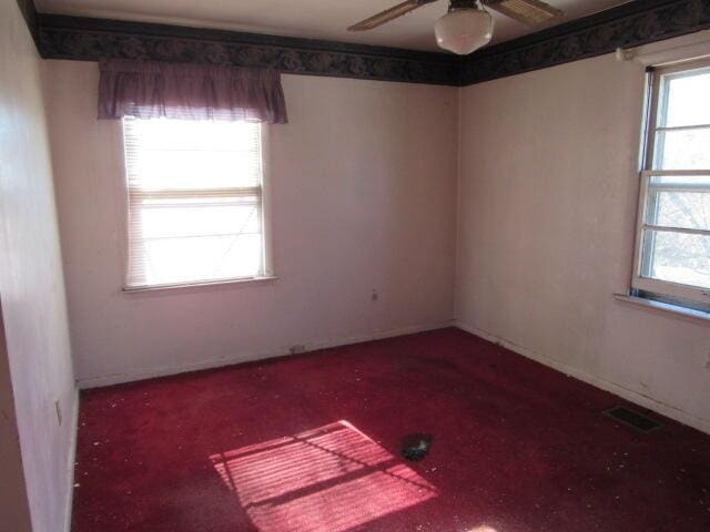 unfurnished room featuring ceiling fan and a healthy amount of sunlight