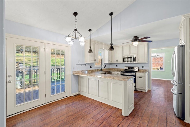 kitchen featuring stainless steel appliances, dark hardwood / wood-style floors, light stone counters, decorative light fixtures, and kitchen peninsula