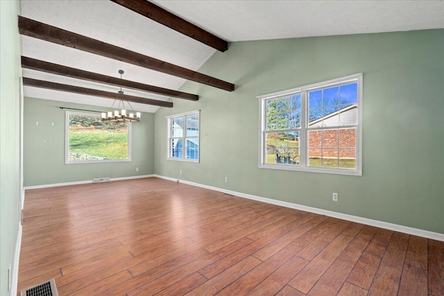 empty room featuring a notable chandelier, vaulted ceiling with beams, and hardwood / wood-style floors