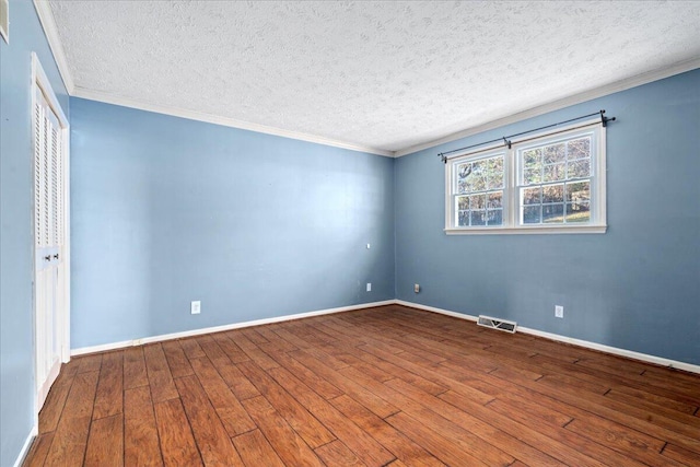 unfurnished room featuring wood-type flooring, a textured ceiling, and crown molding