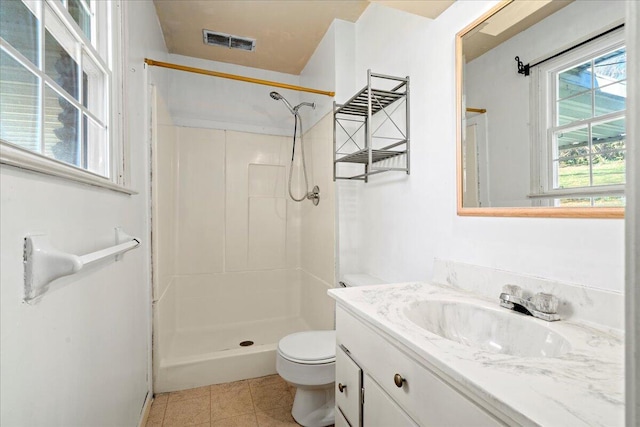 bathroom with walk in shower, vanity, toilet, and tile patterned flooring