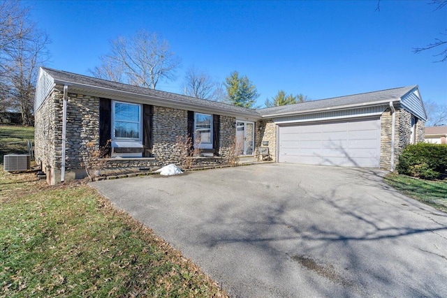 ranch-style home with a garage and central AC