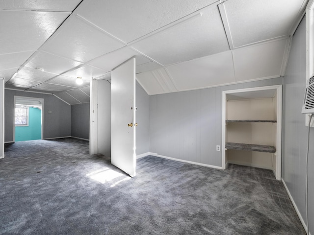 bonus room with dark colored carpet and lofted ceiling