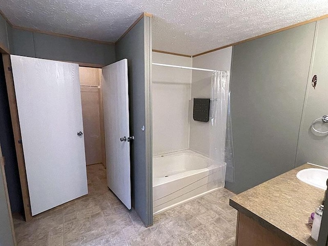 bathroom featuring shower / bath combination with curtain, vanity, and a textured ceiling