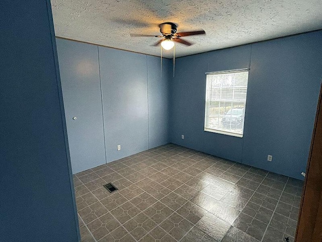 spare room featuring ceiling fan and a textured ceiling
